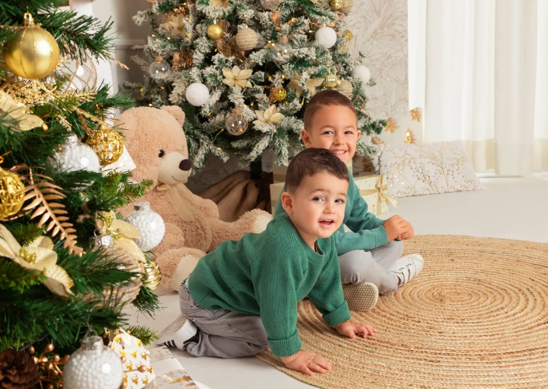 Niño en sesión navideña junto al árbol de Navidad en estudio en Madrid