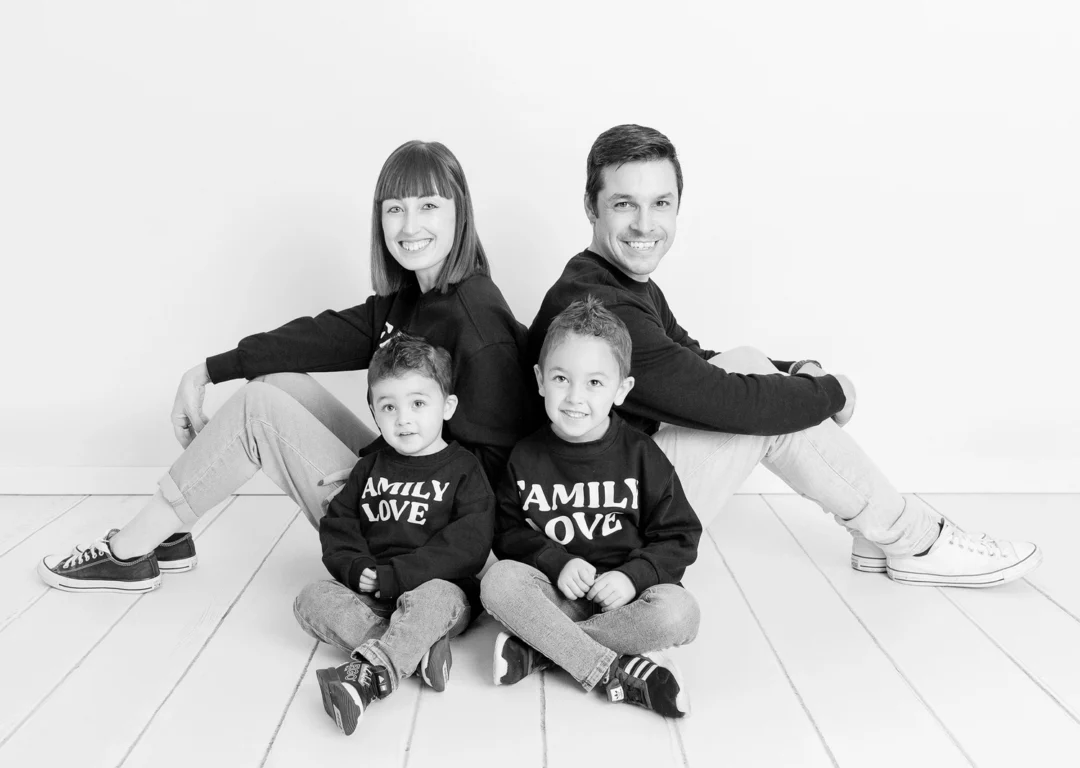 Familia de cuatro en blanco y natural durante sesión fotos