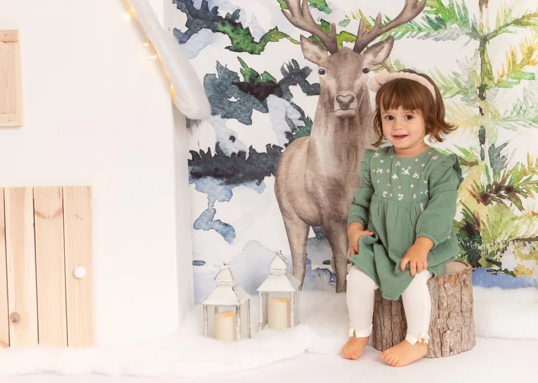 Niño junto a ciervo decorativo en sesión navideña en Guadarrama, Madrid