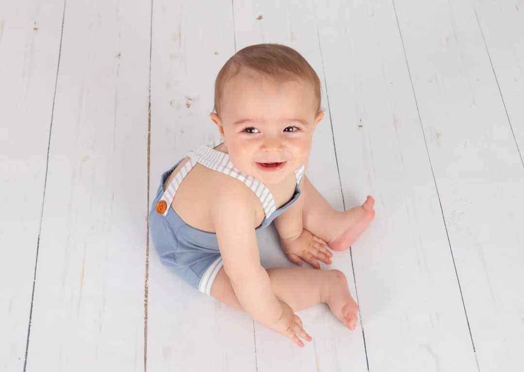 Bebé de 10 meses gateando por el escenario decorado del estudio fotográfico Fotobabybook en Madrid.
