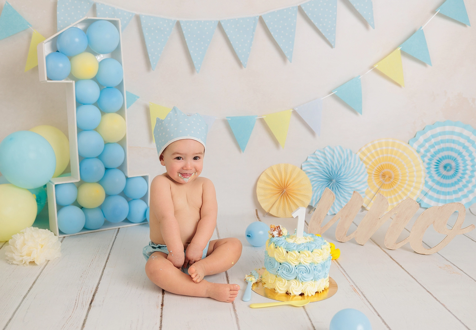Bebé explorando tarta Smash Cake azul sin azúcar en sesión de fotos primer cumpleaños