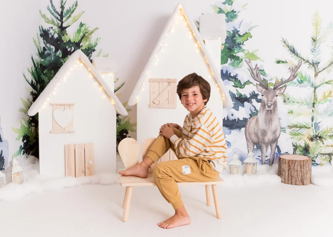 Niño junto a casita de madera en sesión de Navidad en la Sierra de Madrid