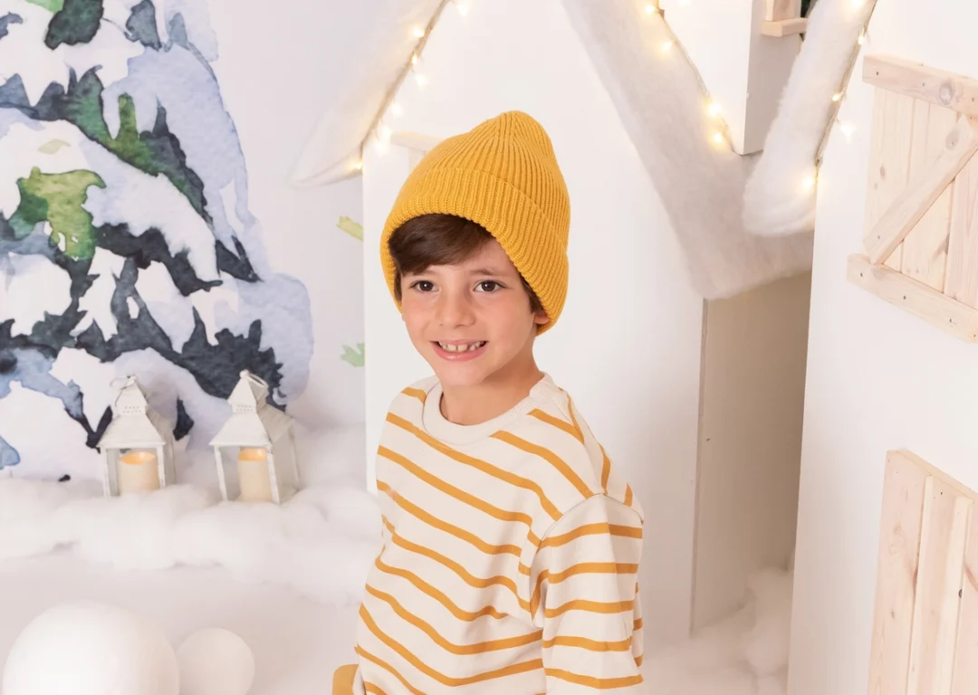 Niño con gorro mostaza en sesión navideña en estudio en Guadarrama, Madrid