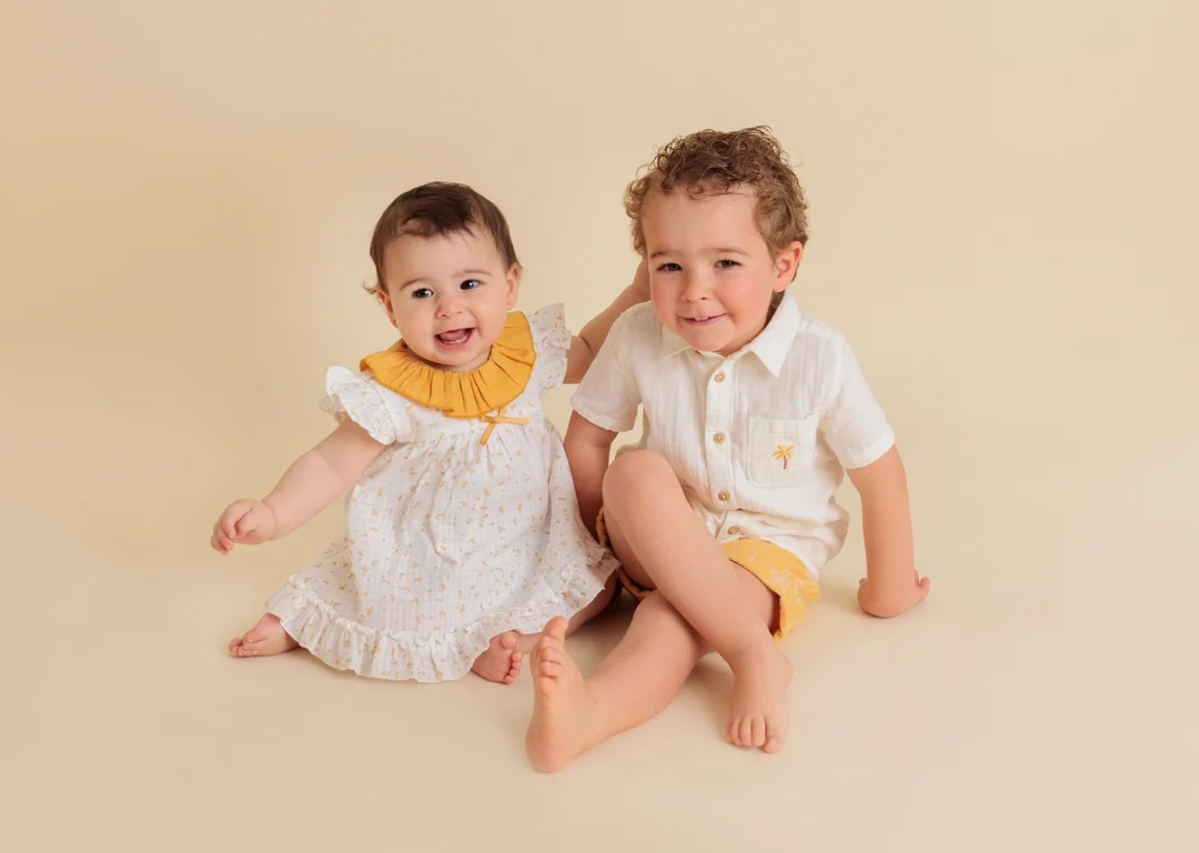 Hermano mayor con su hermana bebé de 8 meses en un reportaje fotográfico infantil natural en Guadarrama.