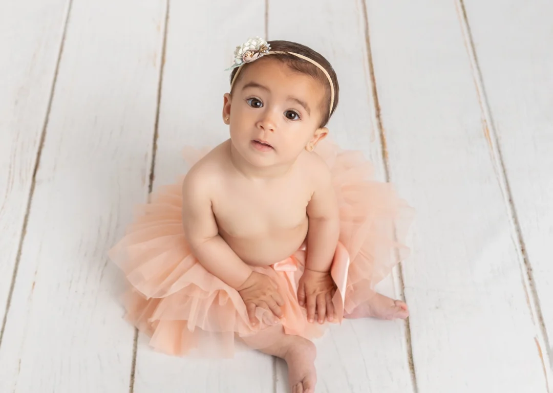 Niña de 9 meses sentada jugando durante su reportaje de fotos en la Sierra de Madrid.