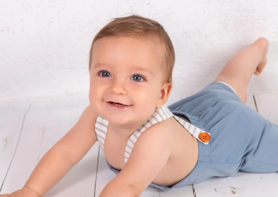 Primer plano de un bebé de 8 meses riendo a carcajadas en un estudio fotográfico de la Sierra de Madrid.