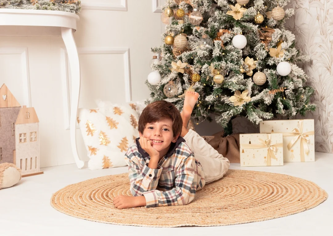 Niño tumbado junto al árbol de Navidad en estudio en la Sierra de Madrid