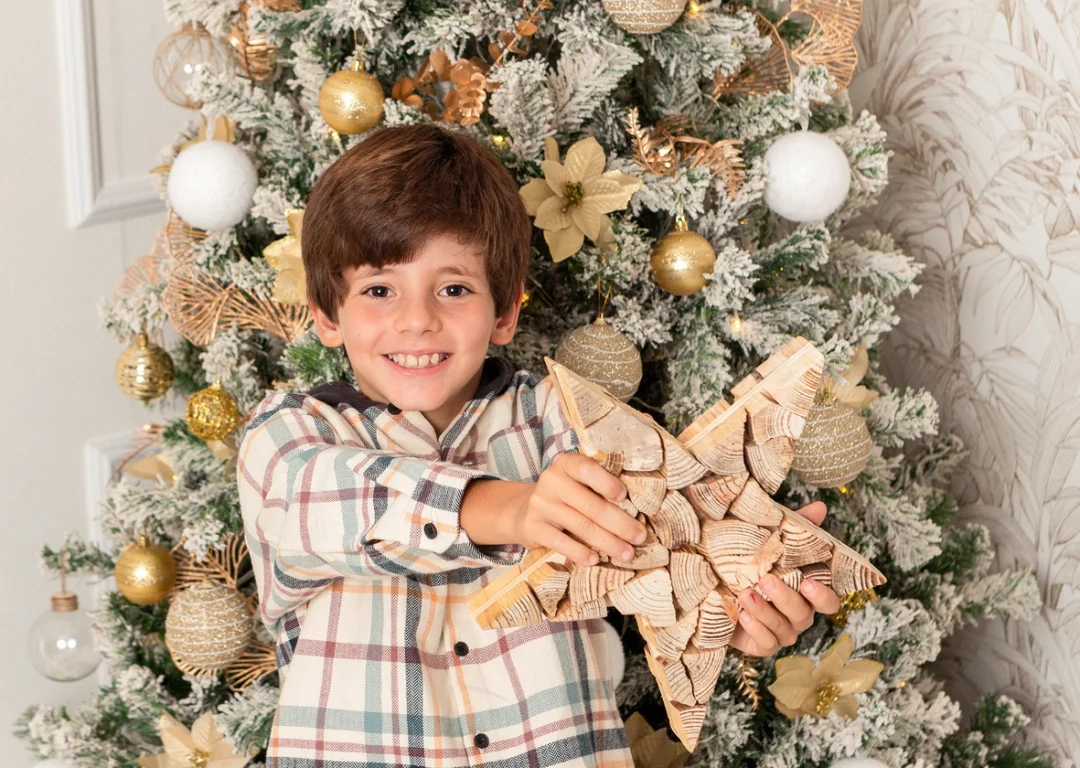 Niño con estrella junto al árbol de Navidad en sesión navideña en Guadarrama, Madrid