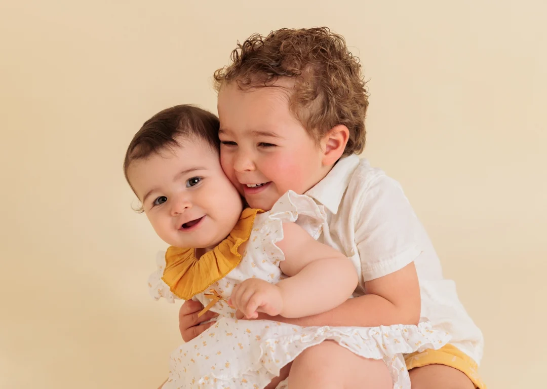 Fotografía de hermanos compartiendo un momento tierno en estudio de Guadarrama.