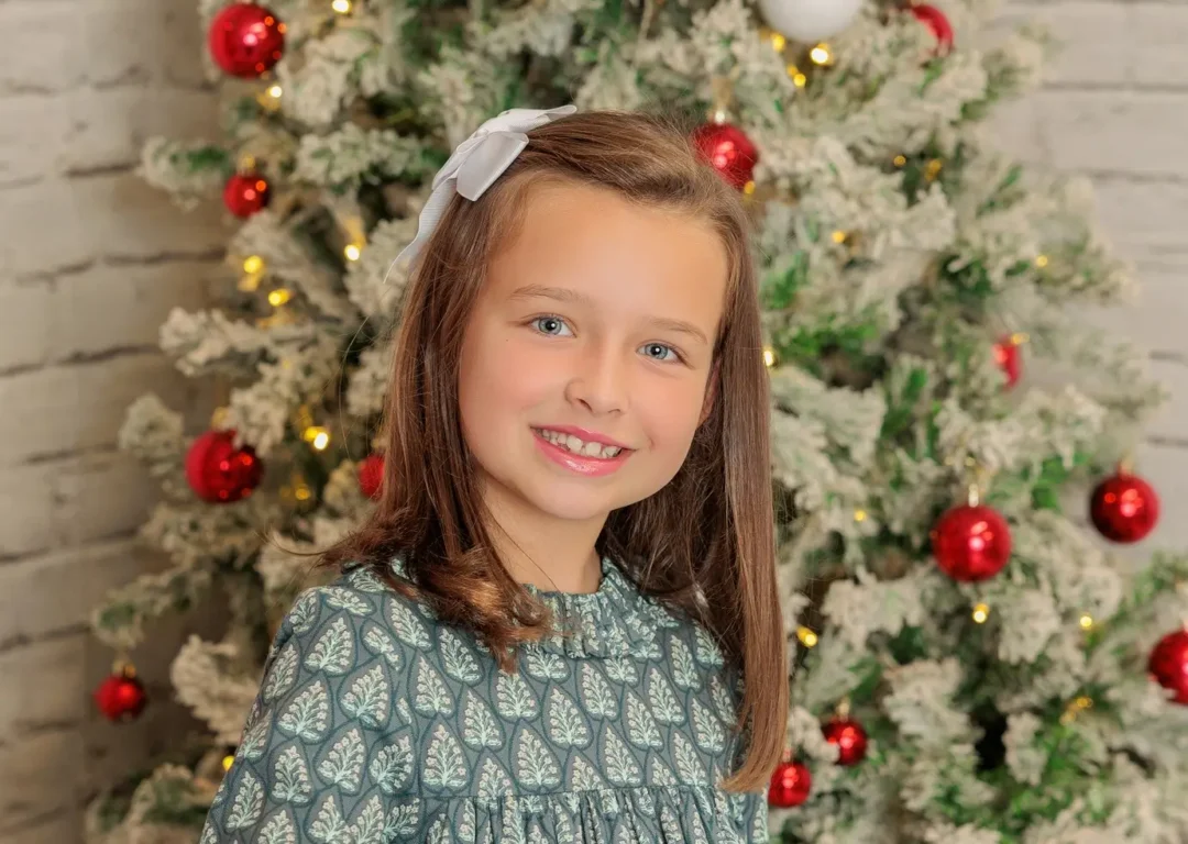 Retrato navideño de niña con árbol de Navidad en estudio fotográfico en Guadarrama, Madrid