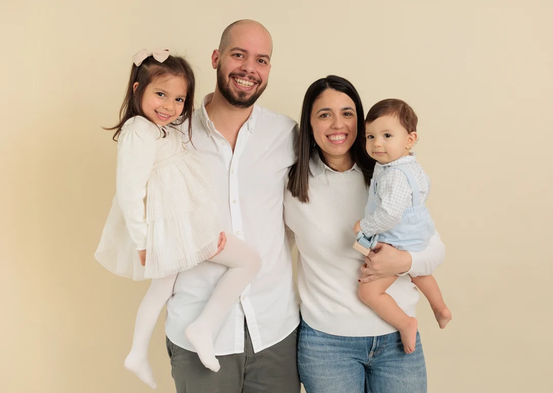 Padres cargando hijo en brazos sesión familia