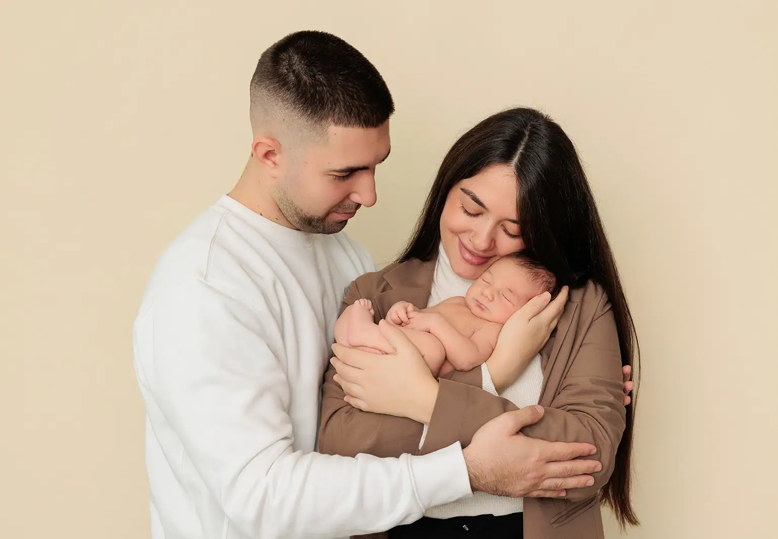 Papás con bebé recién nacido reportaje fotográfico familia